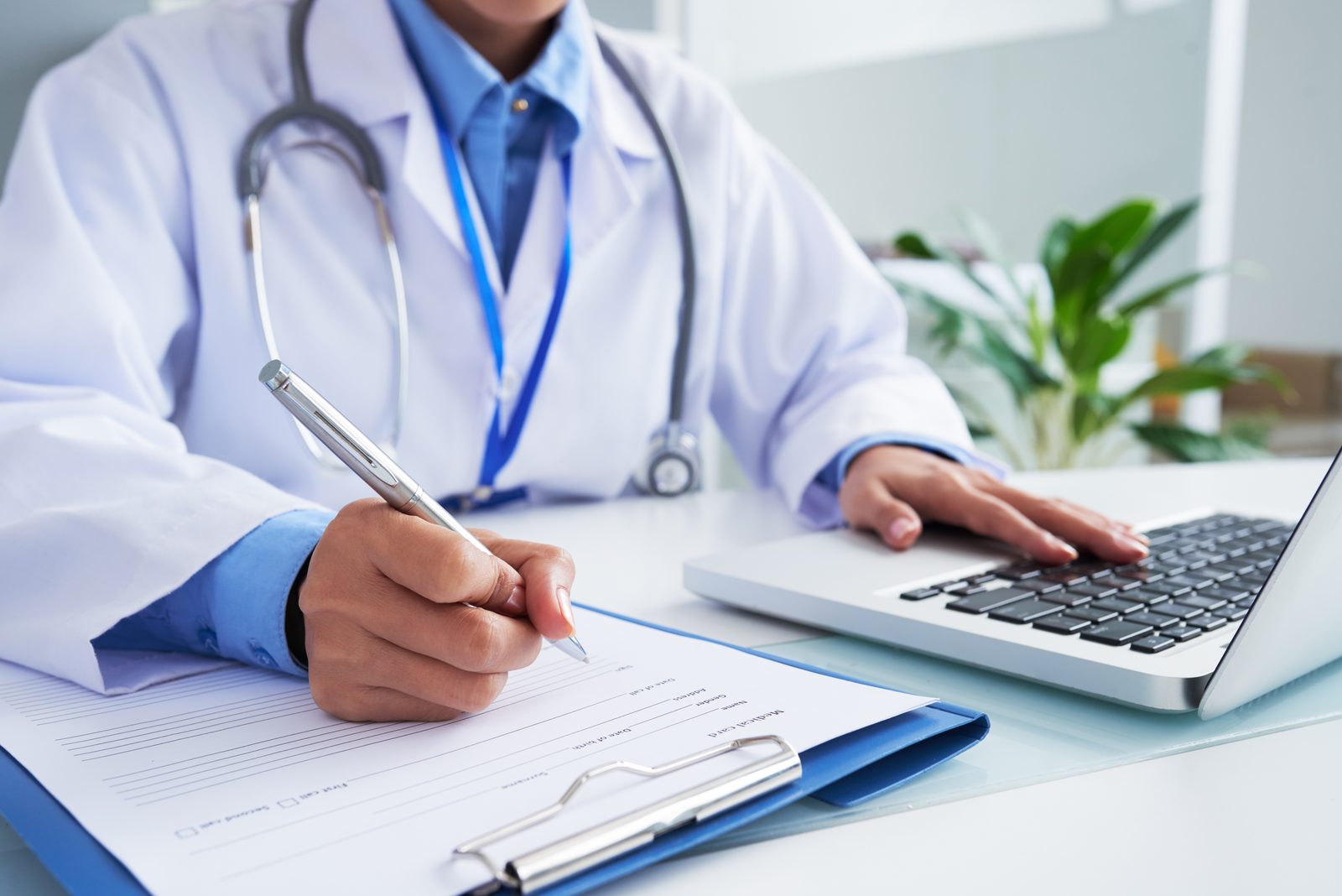 Médica da Clínica Entourage preenchendo ficha de atendimento